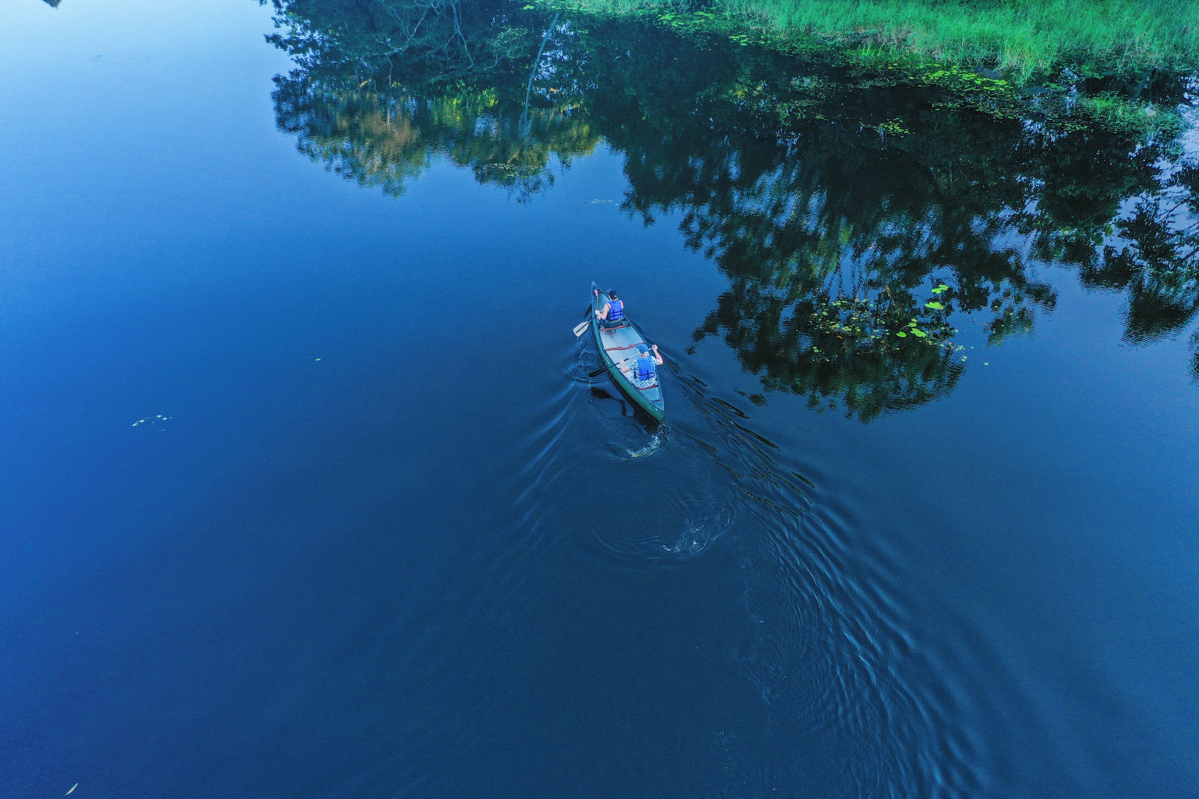 A calm body of water with a single canoe.
