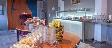 A buffet setup with various food items and glass containers.