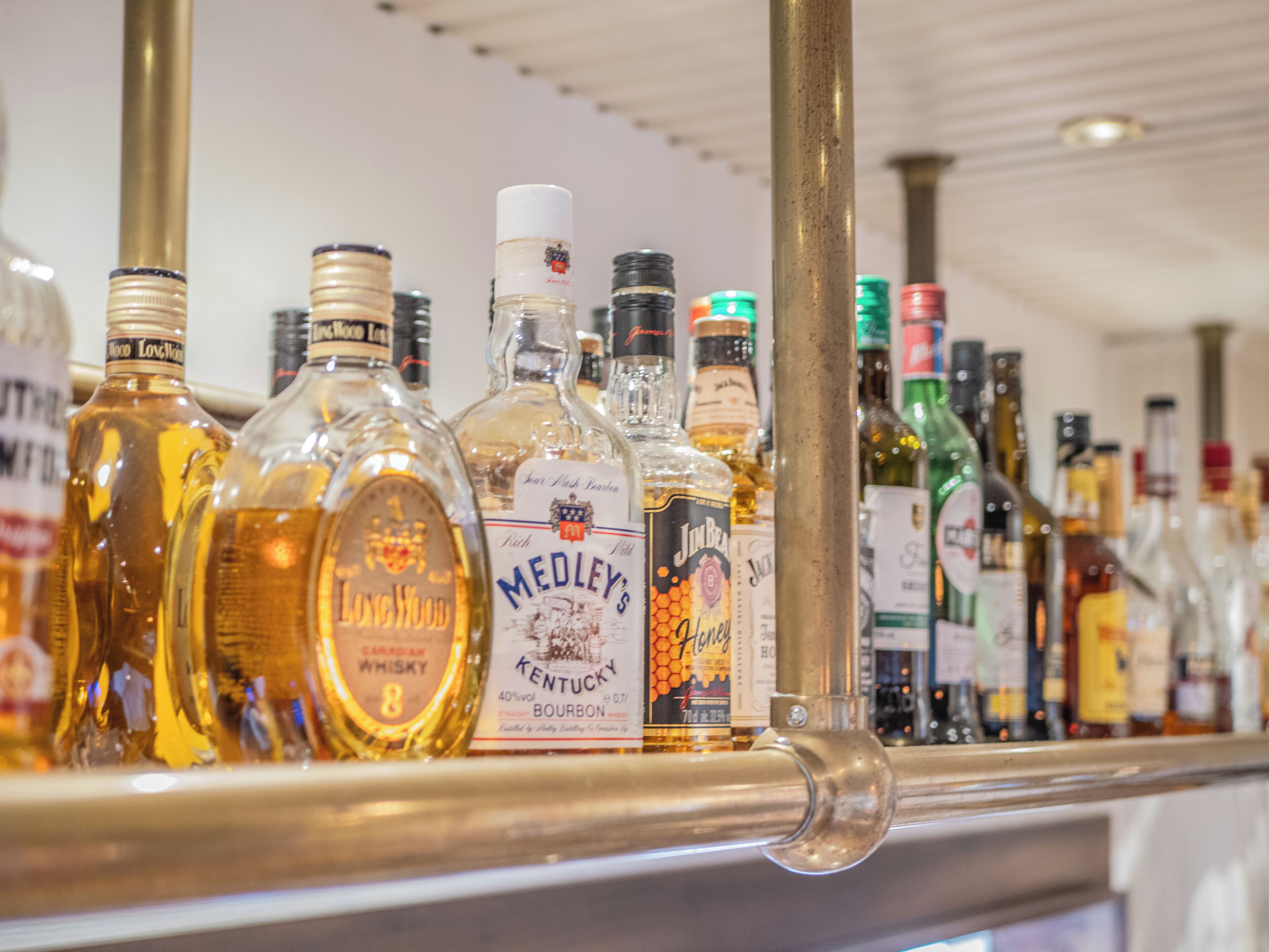 A variety of liquor bottles on a shelf.