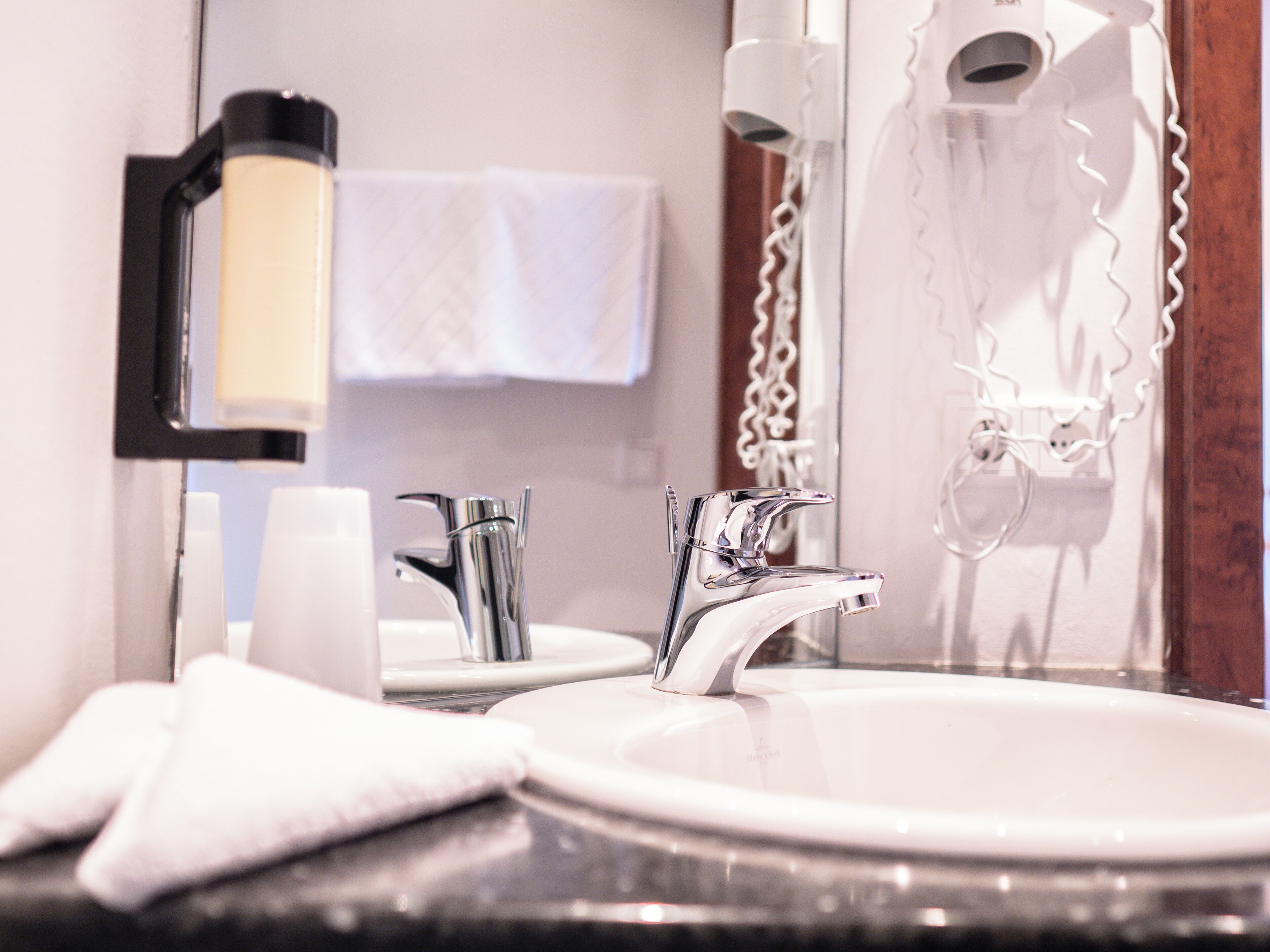 Ein Badezimmer mit Waschbecken, Spiegel und Handtuchhalter.
