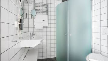 Un bagno moderno con un lavandino bianco, cabina doccia in vetro e un water.