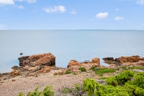 Een kustlandschap met rotsformaties en een rustige zee.