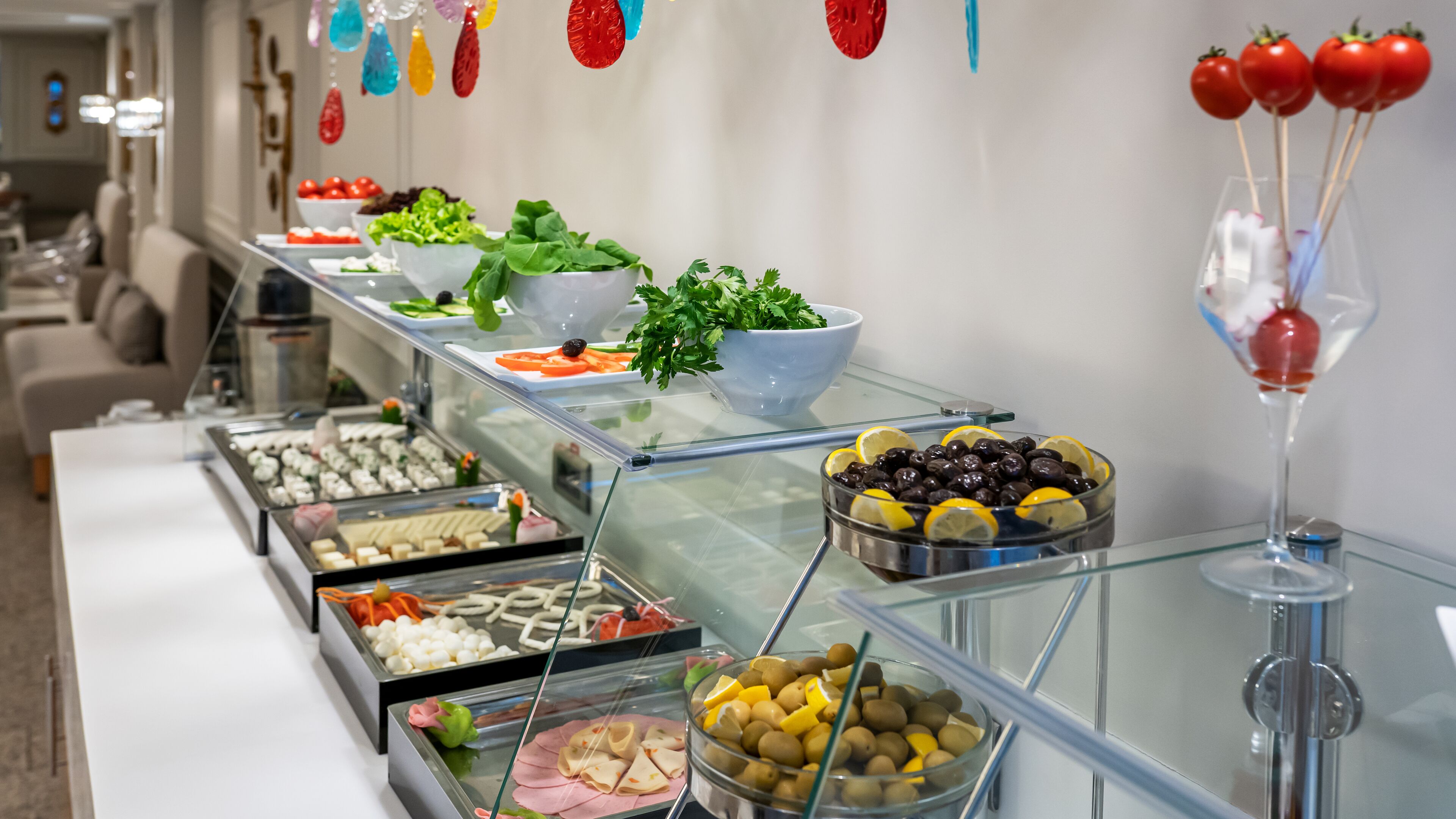 A buffet with various food items including salads, fruits, and desserts.
