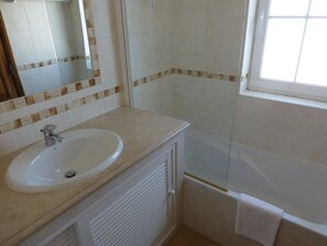 Un baño con lavabo, espejo y ducha.