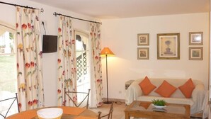 Un salon avec un canapé, une table basse et des rideaux.