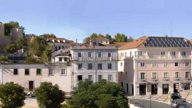 Une rangée d’immeubles à étages, présentant un mélange de styles architecturaux, dont un bâtiment doté d’un toit recouvert de panneaux solaires.