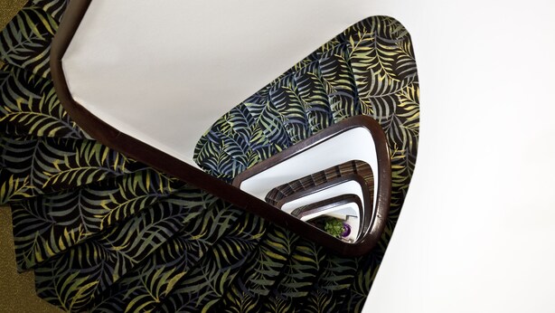Una silla con tapizado estampado en hojas y superficie reflectante.