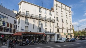 Un hotel de varios pisos con un estilo arquitectónico europeo clásico, que cuenta con balcones y un restaurante en la planta baja.