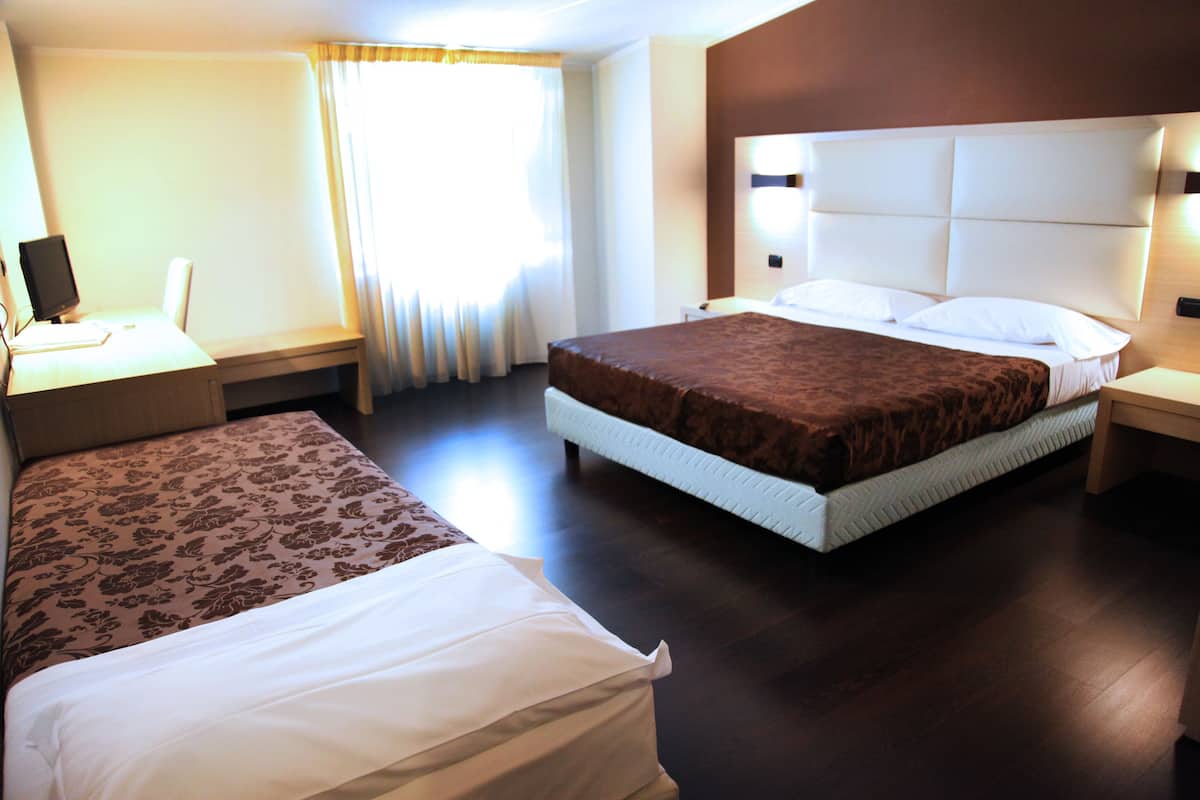 Una habitación de hotel con dos camas, un escritorio y una silla.