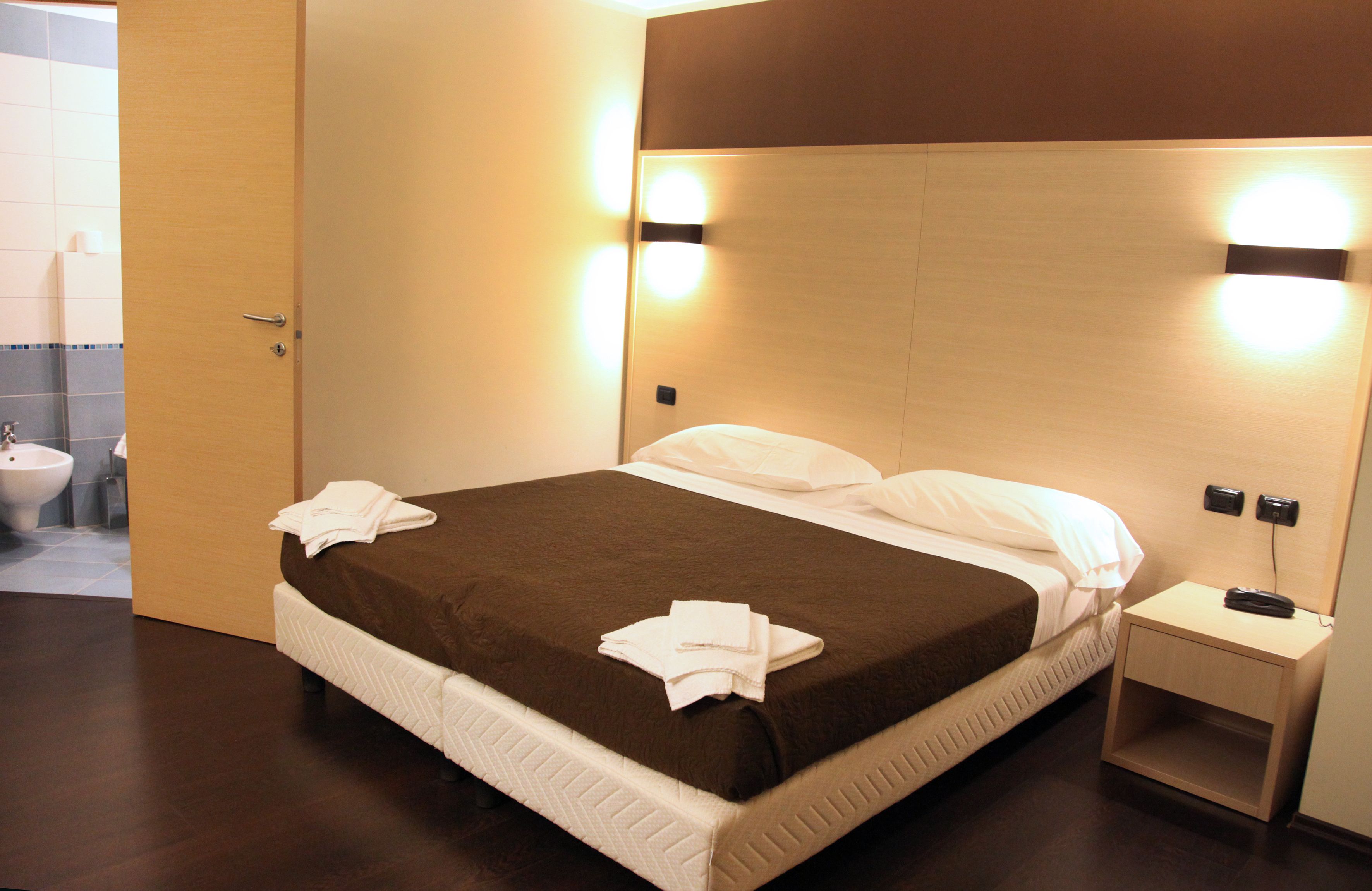 Une chambre d’hôtel avec un lit, une table de chevet et une petite table d’appoint.