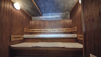 Una sauna con pareti in legno, una panca e una luce al soffitto.