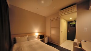 A hotel room with a bed, bedside table, lamp, wardrobe, and a desk with a chair. - Dormy Inn Akita Natural Hot Spring (Akita)