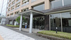 A modern hotel entrance with a covered walkway, large windows, and a tiled facade. - Dormy Inn Akita Natural Hot Spring (Akita)