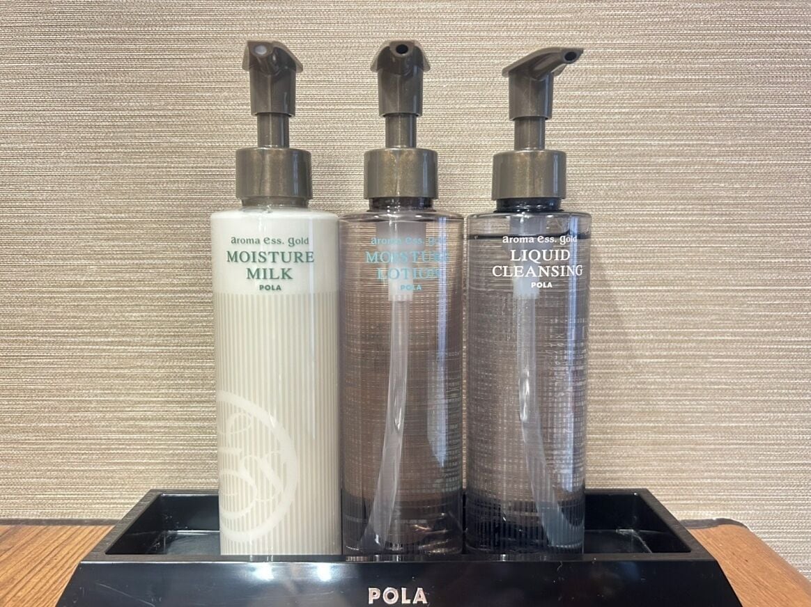Three bottles of POLA skincare products on a black tray.