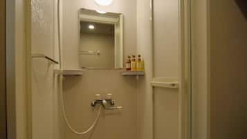 Un baño pequeño y estrecho con ducha, espejo y un estante con artículos de aseo.