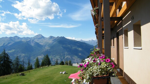 A mountain view from a balcony with a wooden structure and flower boxes. - Hotel La Chance (Gressan)
