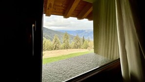 A window with a view of a mountainous landscape, a wooden ceiling, and a curtain. - Hotel La Chance (Gressan)