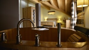 A bathroom with a wooden vanity, a sink, and a bathtub. - Hotel La Chance (Gressan)
