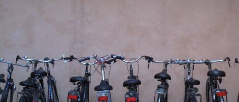 A row of bicycles parked against a wall.