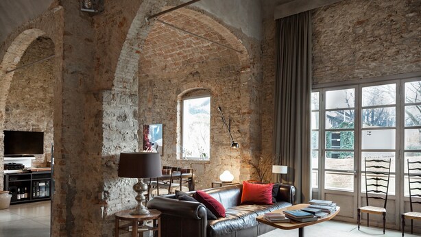 Un salon spacieux avec un canapé en cuir, une table basse et un téléviseur.