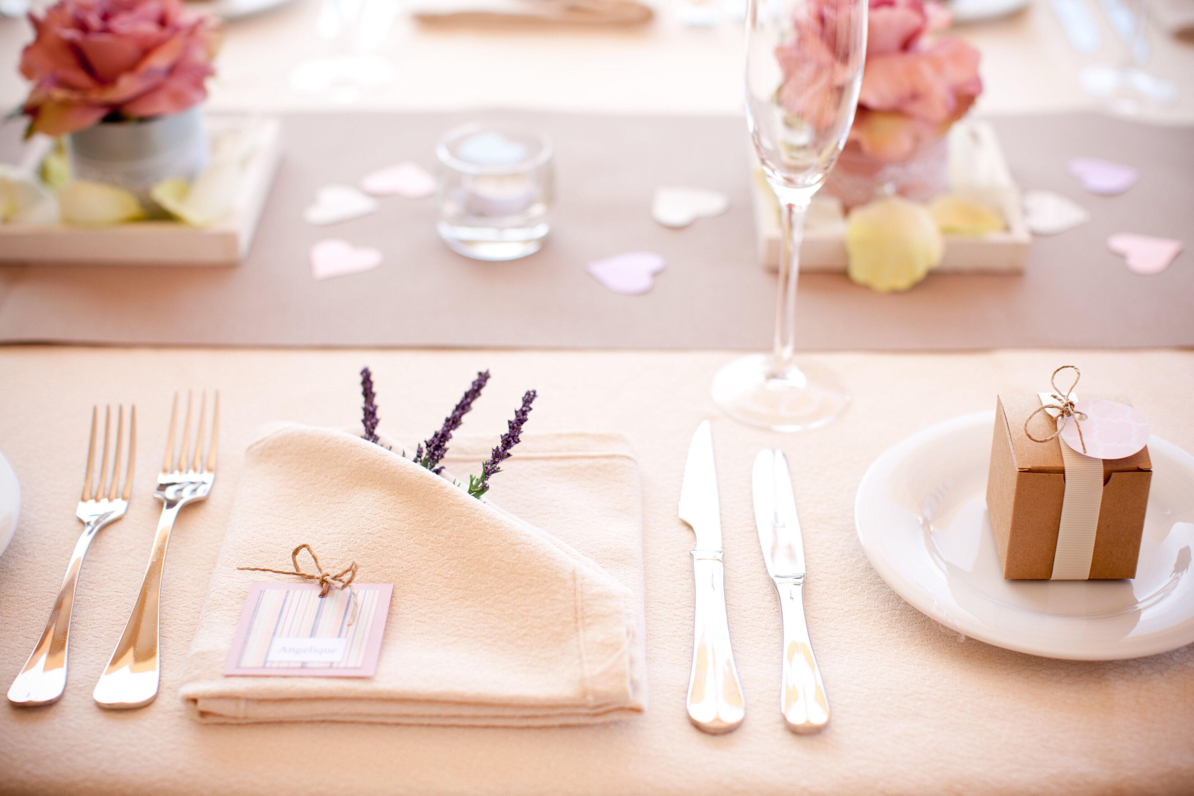 A neatly set table with a folded napkin, a small gift box, and a glass of water.