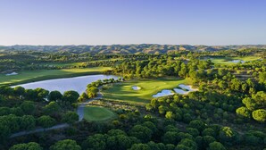 Vista aérea de un campo de golf con varios bunkers, obstáculos acuáticos y un lago.