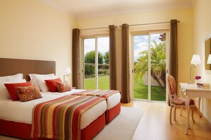 Habitación de hotel con una cama grande, un escritorio y vistas al exterior.