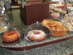 Un mostrador de buffet amb diversos aliments exposats a recipients transparents.