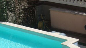 A swimming pool with a curved edge and a set of steps leading into it. - Innocenti (Montecatini Terme)