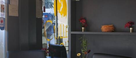 Un interior moderno con mostrador de recepción, zona de estar y estante para vinos.