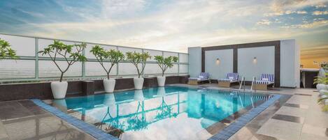 Piscine extérieure, parasols de plage, chaises longues