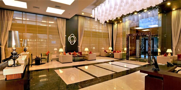 A spacious lobby with a reception desk, seating area, and a large wall with a geometric pattern. - Country Inn & Suites by Radisson, Gurugram Sector 12 (Gurugram)