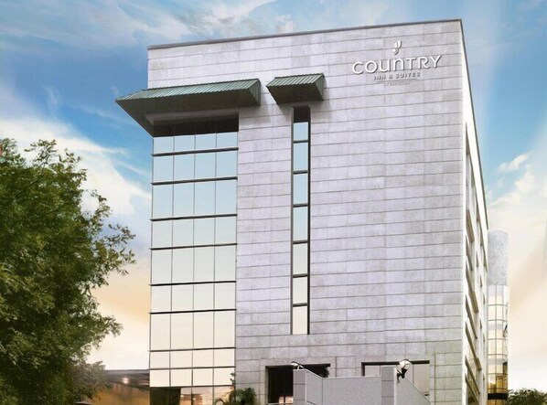 A modern hotel building with a prominent sign reading 'COUNTRY' and '3 SQUITES.'