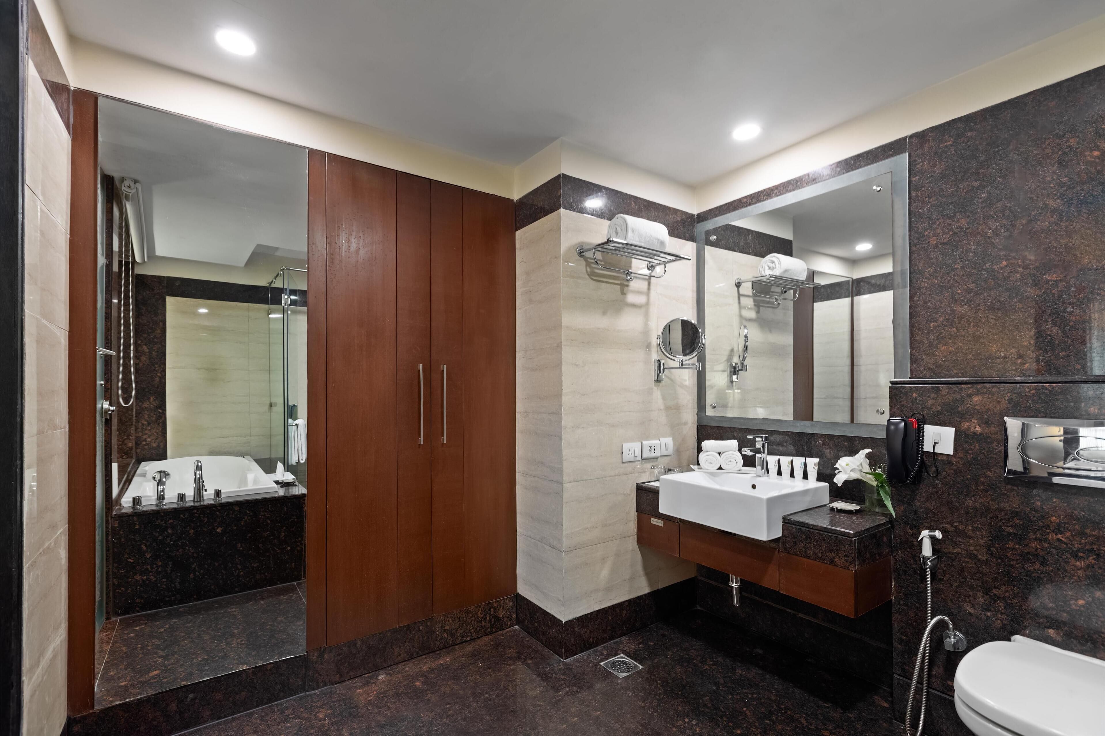A modern bathroom with a bathtub, a sink, a mirror, and a shower.