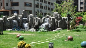 Un patio con una cascada de rocas, bicicletas y pelotas de ejercicio.