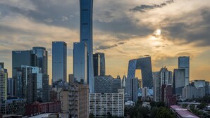 Un paisaje urbano con rascacielos modernos y un edificio destacado con una parte superior de forma curva.