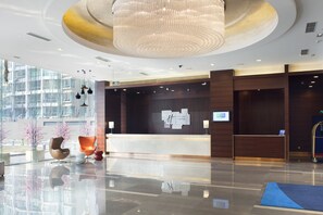 A modern hotel lobby with a reception desk, seating area, and large windows. - Holiday Inn Express Dongzhimen by IHG (Beijing)
