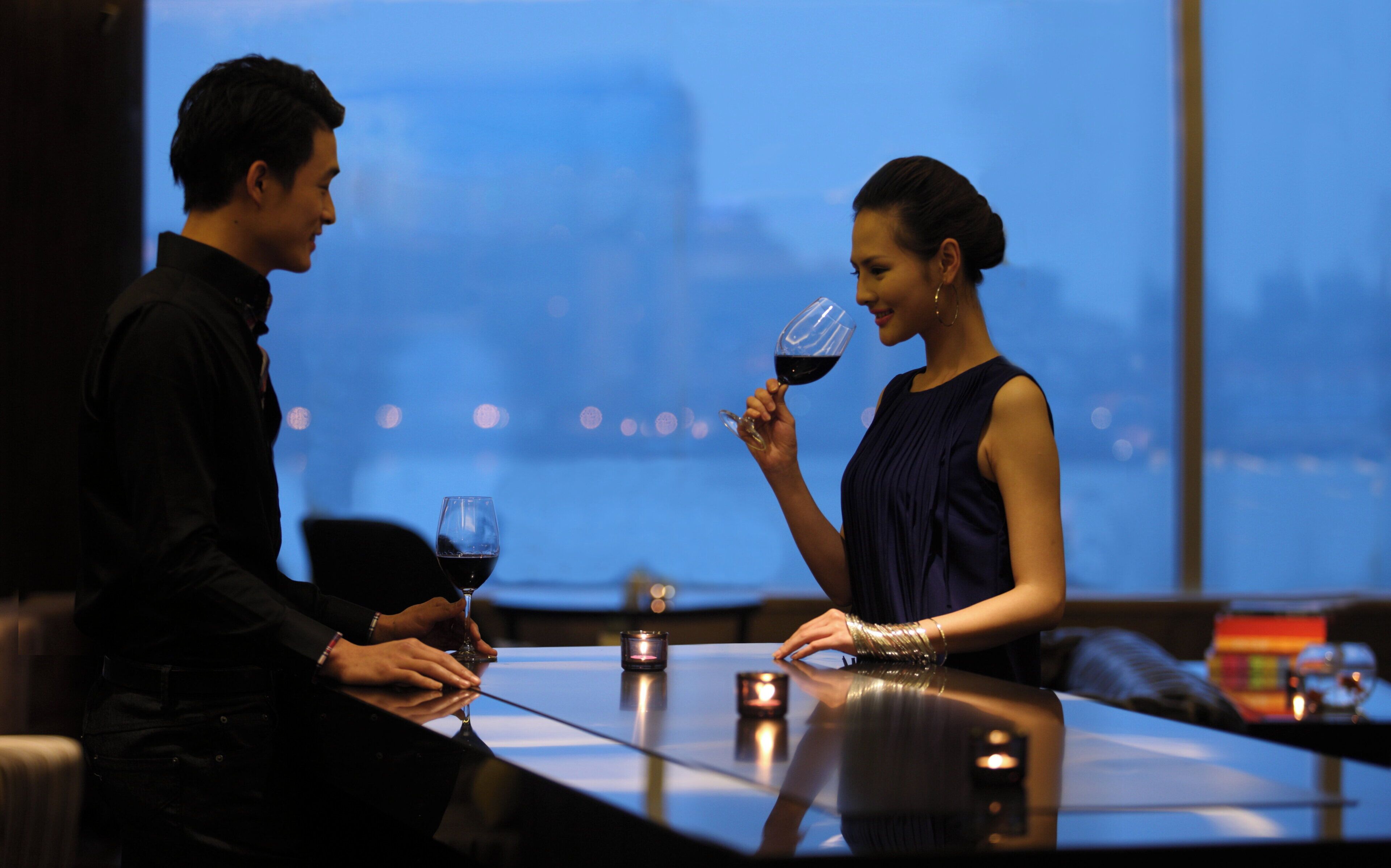 Una pareja sentada en una mesa con vista a la ciudad.