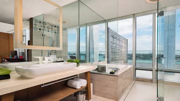 A modern bathroom with a large mirror, a white sink, and a glass shower enclosure.