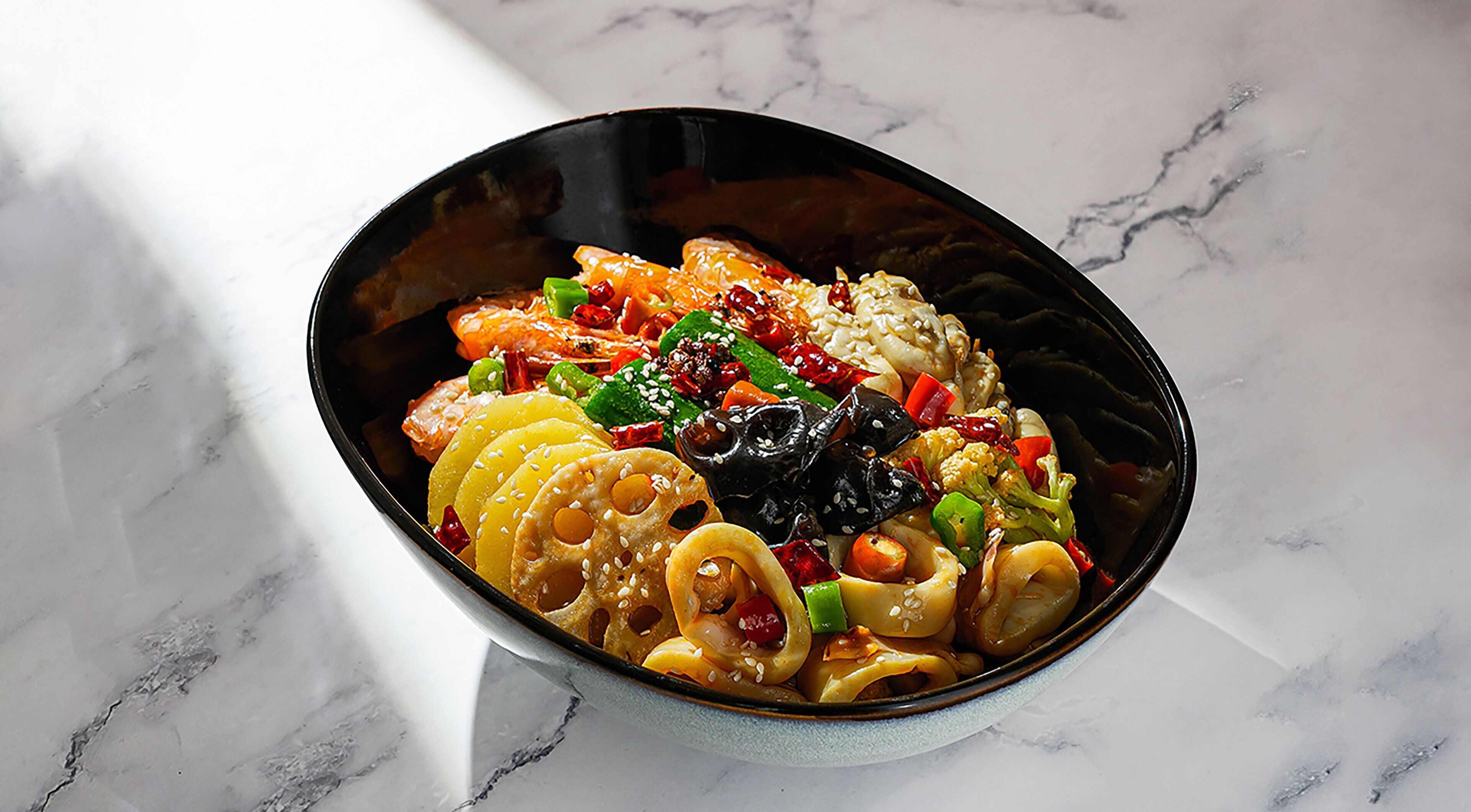 A bowl of colorful food on a marble surface.