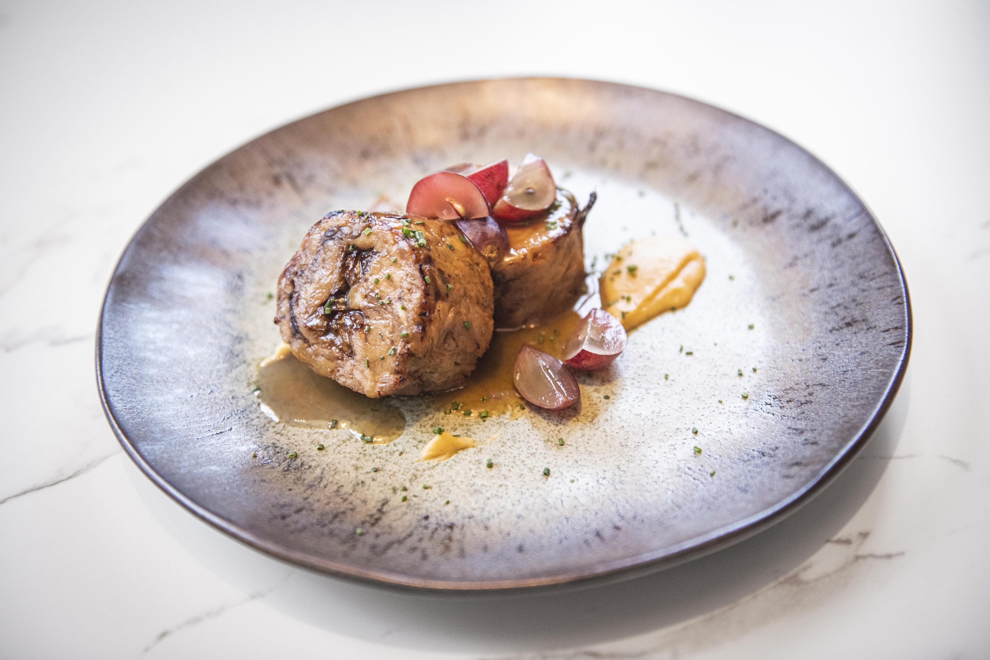 A plate with a piece of meat and vegetables.