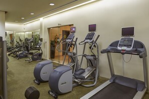 A gym with treadmills, elliptical machines, and weight machines.