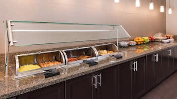 A buffet area with multiple food stations, including a salad bar and a hot food section.