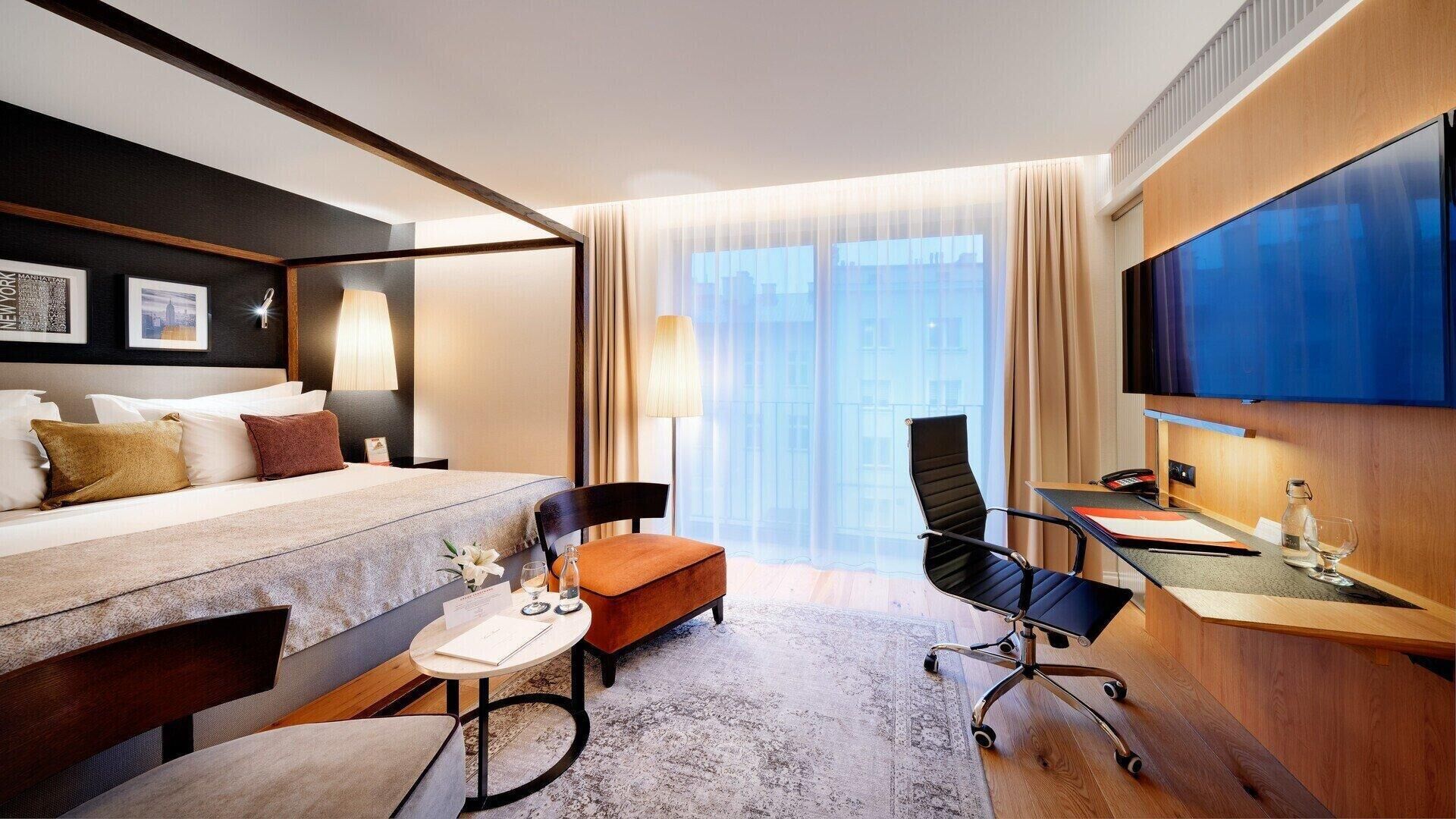 Une chambre d’hôtel équipée d’un lit, d’un bureau, d’une chaise et d’un téléviseur.