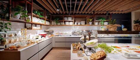 A modern kitchen with wooden beams, white cabinets, and various food items displayed on counters.