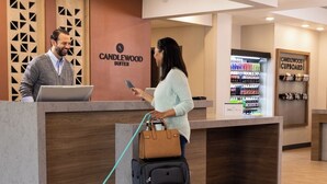 A reception desk at Candlewood Suites with a dog and a suitcase. - Candlewood Suites Decatur Medical Center by IHG (Decatur)