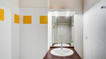 Un baño con dos lavamanos, un espejo y tocador iluminado.