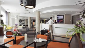 A modern hotel lobby with seating areas, a reception desk, and a bar. - Novotel Suites Malaga Centro (Málaga)