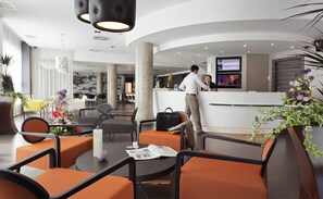 A modern hotel lobby with seating areas, a reception desk, and a bar. - Novotel Suites Malaga Centro (Málaga)