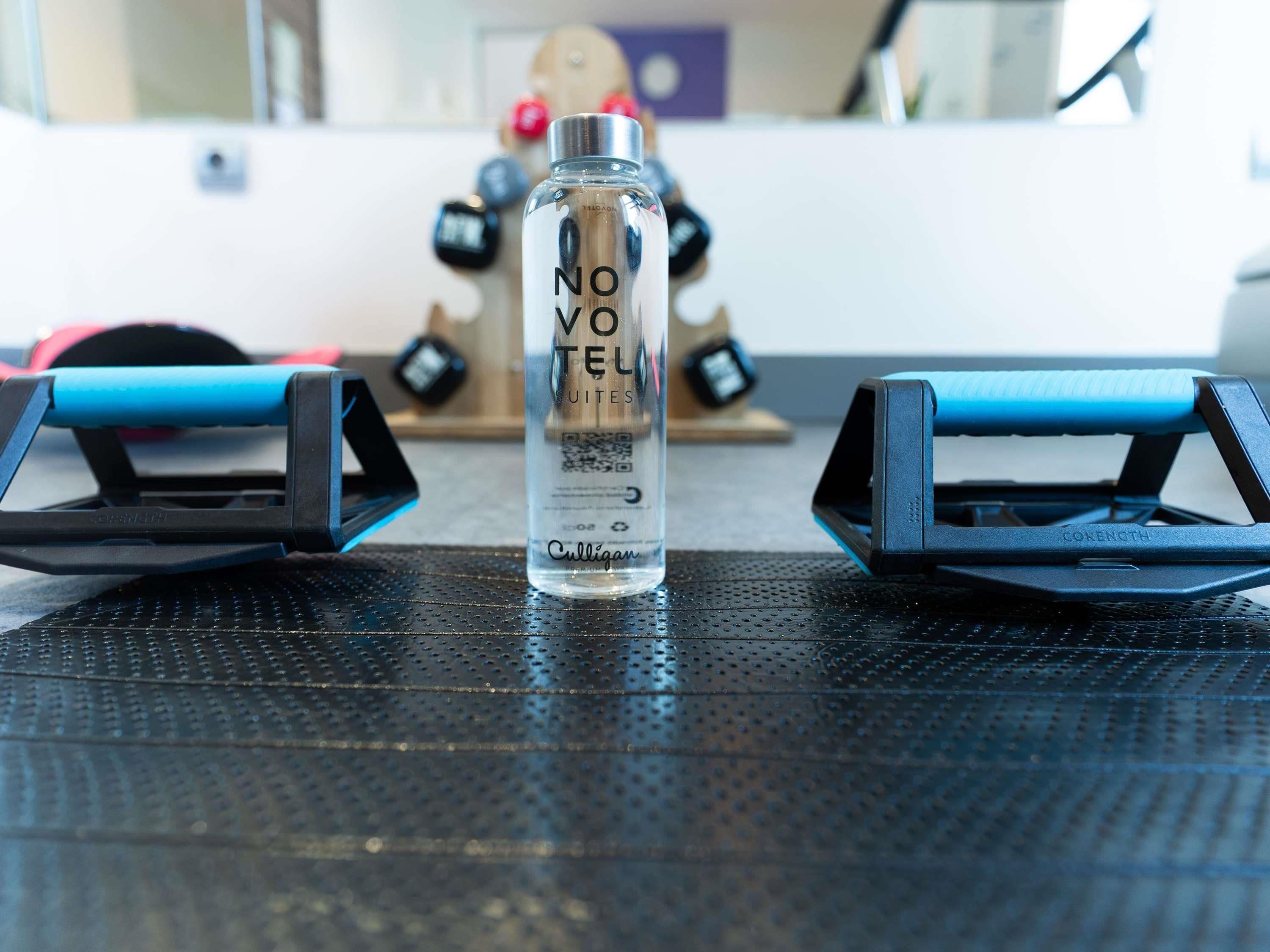 A water bottle labeled 'NOVEL' on a black textured surface.